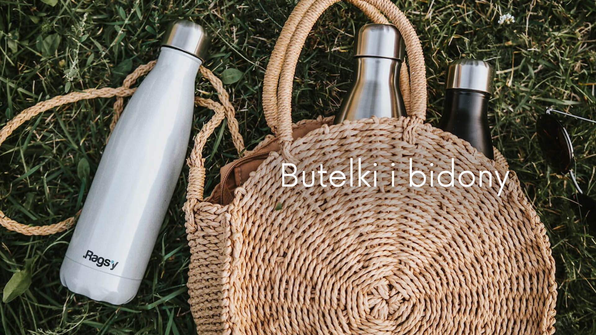 Butelki termiczne leżące na trawie, dwie butelki włożone do damskiej  torebki.